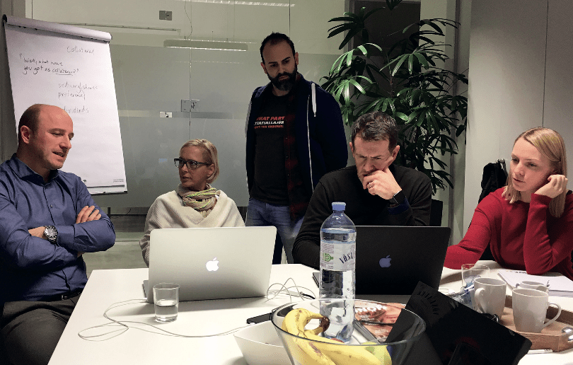 Fabio Sacilotto, Projektleiter bei Topix (li), Manfred Wagner, Leiter Produktion und Technik beim RG Verlag in Wien (stehend), Bernd Gorbach, be-go.at (zweiter von rechts) diskutieren mit Bild- und Layoutverantwortlichen Konzepte, Prozesse und technische Details.