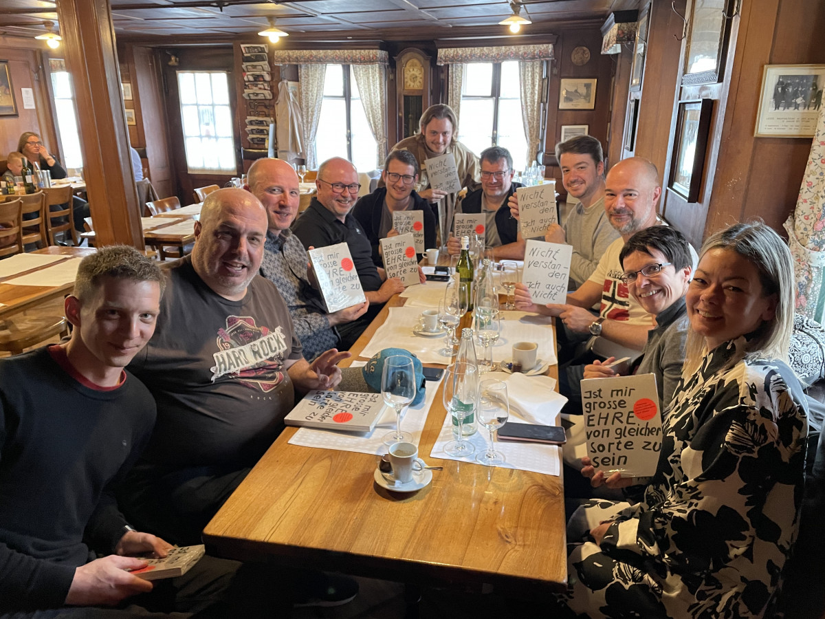 Daniel, Martin, Fabio, Reto, Adrian, Noel, Dietmar, Nicolas, Sven, Bernadette und Aspasia zeigen Dieter (am Fotono) ihr Buchgeschenk.