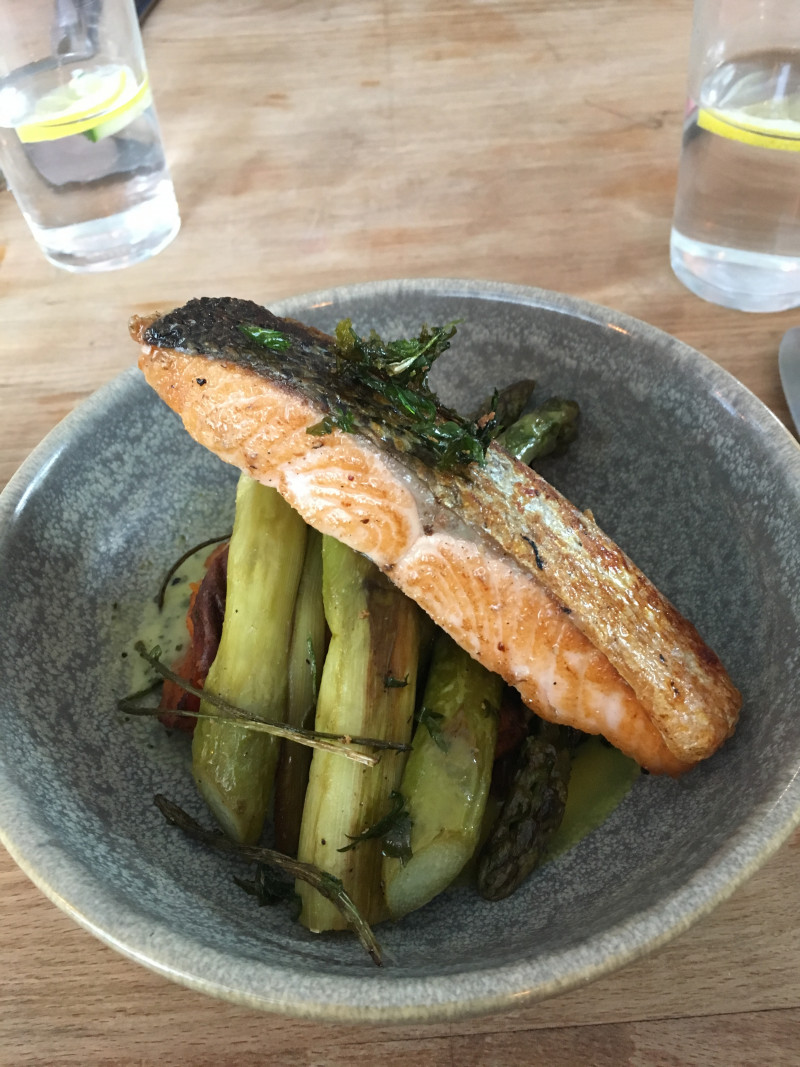Der Lachs auf grünem Spargel.