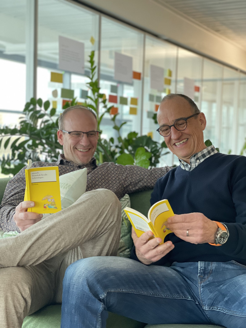 Zwei Männer lesen Buch